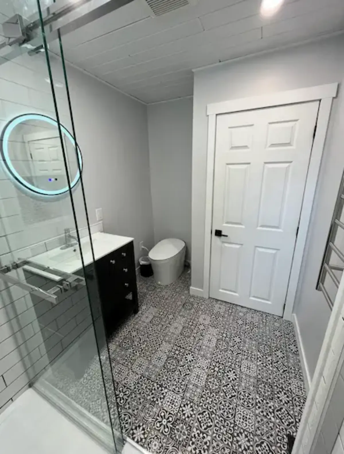 Modern bathroom renovation with LED mirror and glass shower